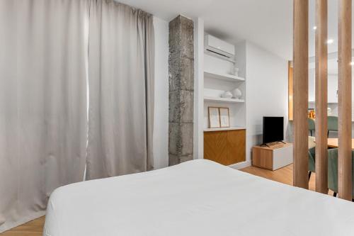 a bedroom with a white bed and a television at Sky Costa Del Sol in Torremolinos