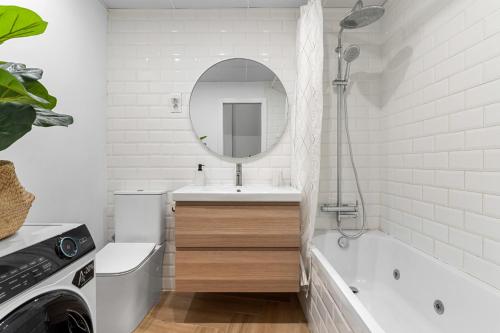 a bathroom with a tub and a sink and a mirror at Sky Costa Del Sol in Torremolinos