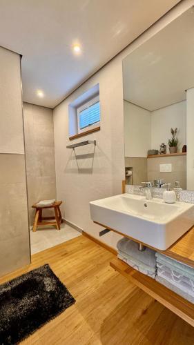 a bathroom with a large white sink and a mirror at Kathi´s Allgäuliebe in Weitnau