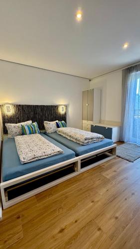 two beds in a room with wooden floors at Kathi´s Allgäuliebe in Weitnau