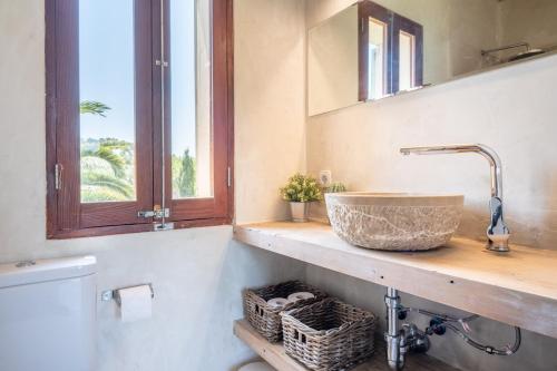 a bathroom with a sink and a toilet and a window at Redonda 2 in Costitx