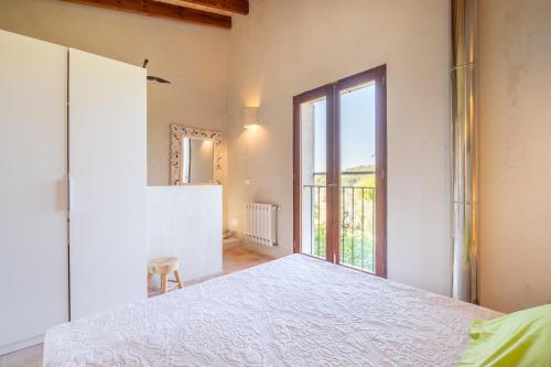 a bedroom with a white bed and a large window at Redonda 2 in Costitx