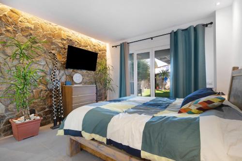 a bedroom with a bed and a stone wall at Villa Indie in Chiclana de la Frontera