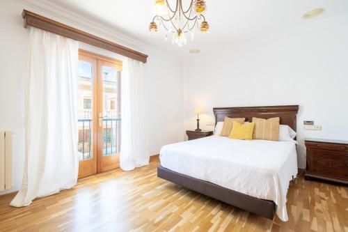 a white bedroom with a bed and a window at Can Maro in Santa Margalida