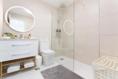 a bathroom with a shower and a toilet and a mirror at Retama in Adeje