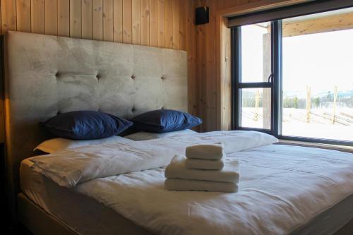 a bedroom with a large bed with a large window at Beitostølens smørblomst in Beitostøl