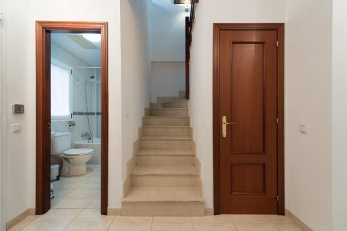 a hallway with a staircase with a wooden door at Casa Angel A 3 in Corralejo