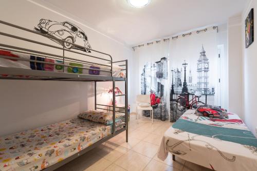 a bedroom with two bunk beds with a car on the wall at Casa Angel A 3 in Corralejo