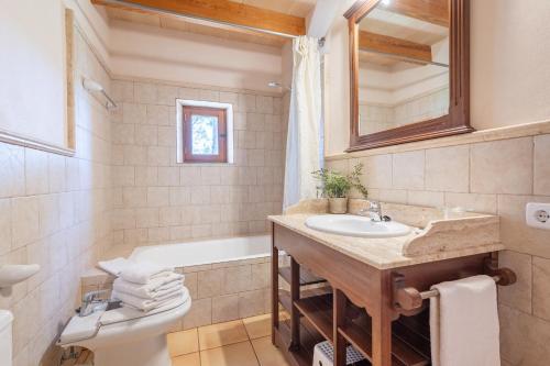a bathroom with a sink and a tub and a toilet at Es Lledoner 2 in Islas Baleares