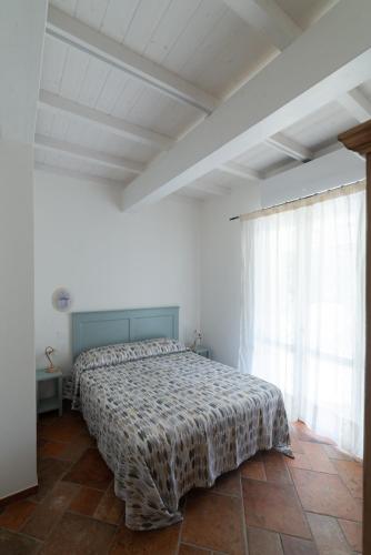 a bedroom with a bed and a large window at Il Timo in Marciana