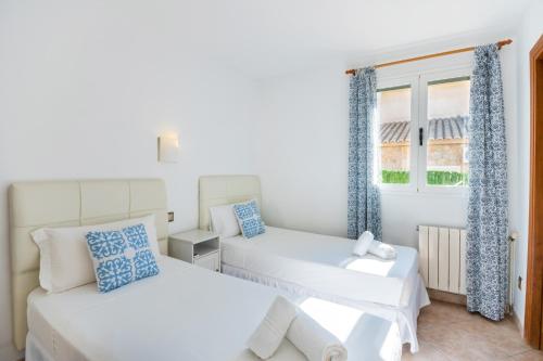 a bedroom with two beds and a window at Villa Loli in Alcudia