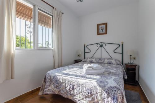 a bedroom with a bed with a blue and white bedspread at Cortijo Encarni in Frigiliana