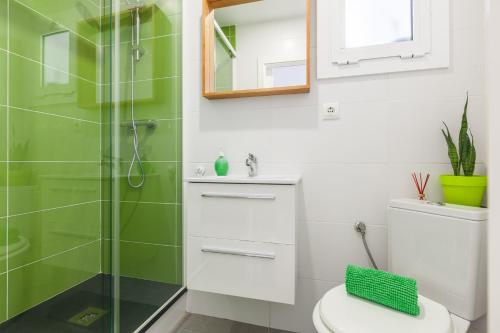 a bathroom with a toilet and a glass shower at Boutique Beach Mataró in Mataró