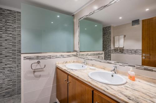 a bathroom with two sinks and a large mirror at Villa Can Serra in Port de Pollensa
