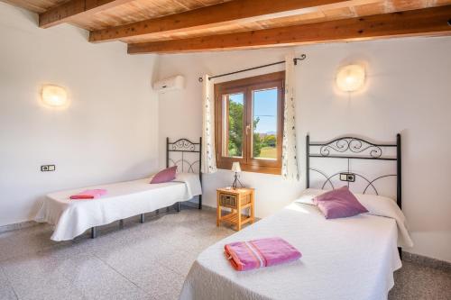 two beds in a room with a window at Villa Can Serra in Port de Pollensa