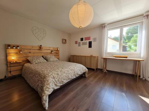 a bedroom with a bed and a desk and a window at Villa des ermites in Favières