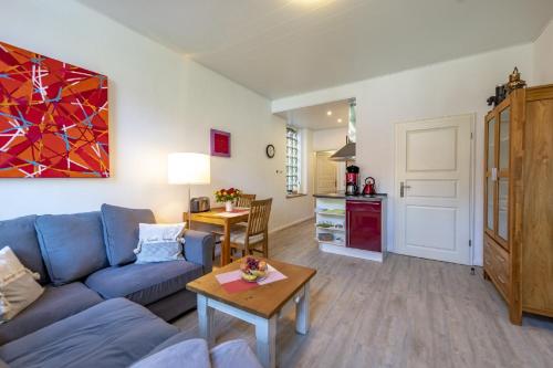 a living room with a blue couch and a table at Ferienwohnungen Wiese - Nickel 2 in Arnis