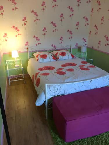 a bedroom with a bed with flowers on the wall at Chez Manon in Massangis