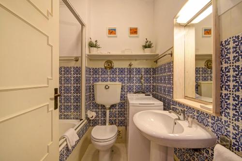 a blue and white bathroom with a toilet and a sink at Villa Apple in Vale do Lobo