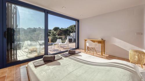 a bedroom with a large window with a view of a balcony at Costacabana - Casa Adora in Tossa de Mar