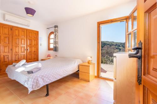 a bedroom with a bed and a large window at Villa Rosa in Calonge