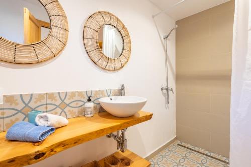 a bathroom with a sink and mirrors on the wall at Marina Ses Covetes in Campos