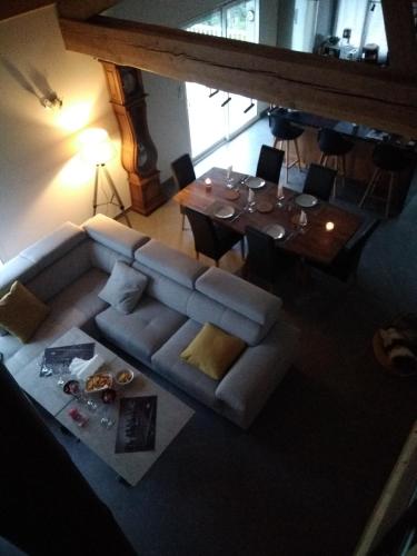 Draufsicht auf ein Wohnzimmer mit Sofa und Tisch in der Unterkunft Maison Chalet in Le Nayrac