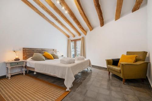 a bedroom with a bed and a chair at El racó de les escales in Tivissa