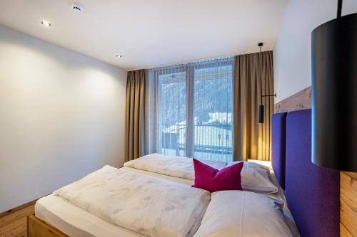 a bedroom with a bed with a large window at Stoana Apt 2-2 in San Giacomo