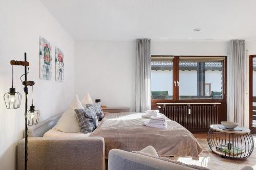 a white bedroom with a bed and a window at Ferienwohnung Niki in Titisee-Neustadt