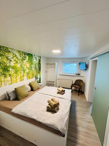 a bedroom with a large bed with two towels on it at Haus Birkenösch in Aach-Linz