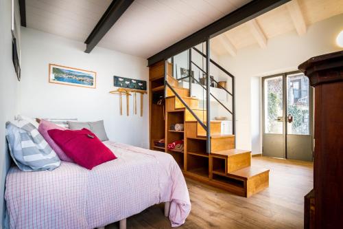 a bedroom with a bed with a red pillow on it at Loft e Veranda sul Lago di Como in Blevio