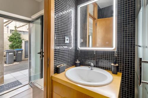 a bathroom with a sink and a glass shower at Annex Bedroom - Oporto Garden in Porto