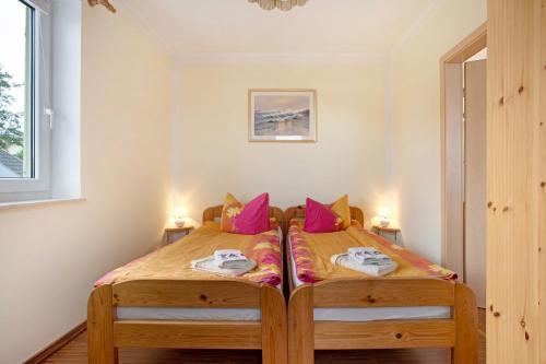 a bedroom with two twin beds with pink pillows at Ilse - Ferienwohnungen Zinnowitz in Zinnowitz
