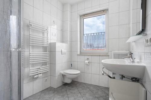 a white bathroom with a toilet and a sink at Ilse - Ferienwohnungen Zinnowitz in Zinnowitz