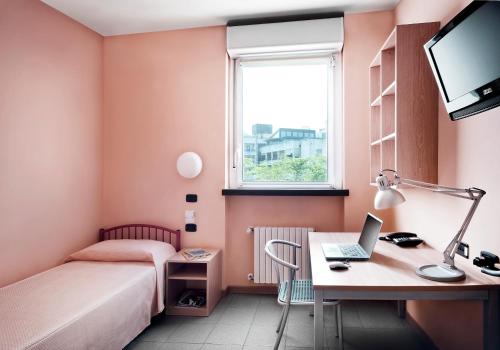 1 dormitorio con escritorio, 1 cama y ordenador portátil en La Cordata Accommodation - Zumbini 6, en Milán