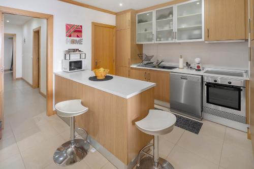 a kitchen with a counter and stools in it at Quinta da Faya in Angra do Heroísmo