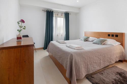 a bedroom with a large bed with a wooden headboard at Quinta da Faya in Angra do Heroísmo
