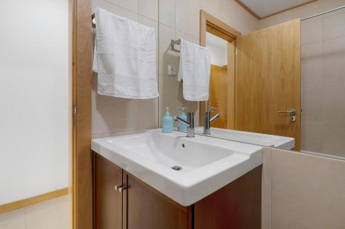 a bathroom with a white sink and a mirror at Quinta da Faya in Angra do Heroísmo