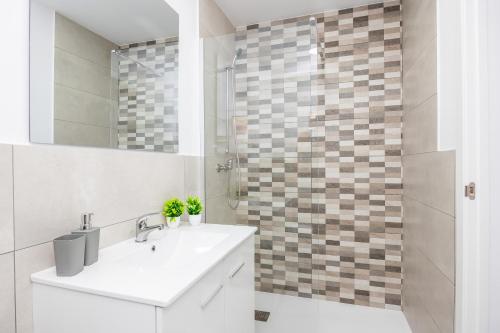 a white bathroom with a sink and a shower at Gran Sol Family 8 in Felanitx