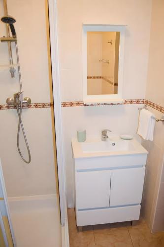 a white bathroom with a sink and a mirror at Casa Vitorino in Sagres