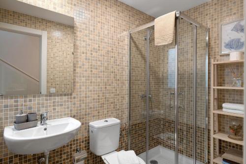 a bathroom with a toilet and a sink and a shower at Casa Reguemar in Arrecife