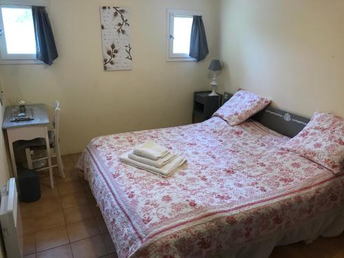 a bedroom with a bed with two towels on it at Gite La Lède in Bias