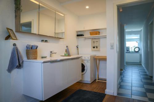 a kitchen with white cabinets and a washer and dryer at Second Home in Birlenbach