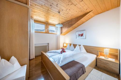 a bedroom with a large bed and a wooden ceiling at Eichernhof Apartment Apfelblüte in Verano