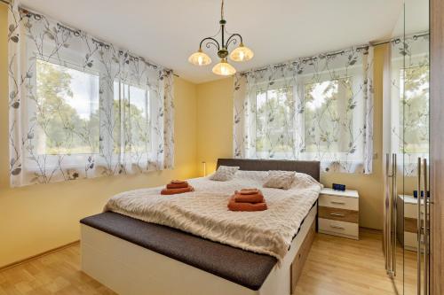 a bedroom with a bed and two windows at 2 Zimmer Ferienwohnung 69 Qm in Mittenwalde