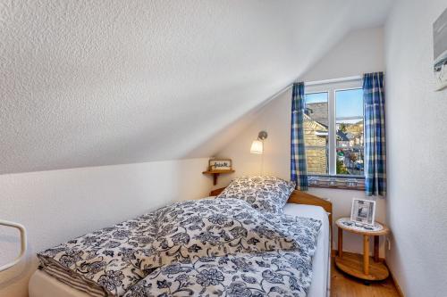 a small bedroom with a bed and a window at Ferienhaus Glücksschmiede in Schmallenberg