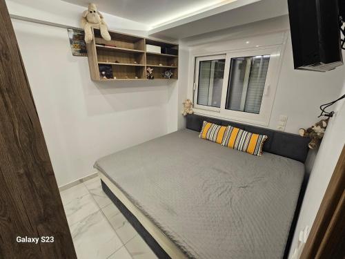 a small bed in a room with a window at Blue Wave in Paralia Katerinis