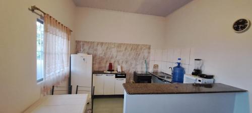 a kitchen with a white refrigerator and a counter top at Flat JM 05 in Parauapebas