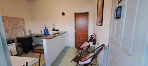 a kitchen with two chairs and a table and a counter at Flat JM 05 in Parauapebas